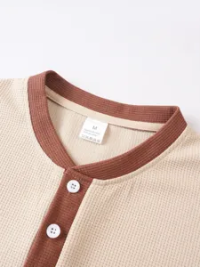 Detailed shot of men's waffle knit Henley collar short sleeve top with contrast trim.