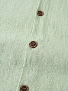 Gros plan sur le tissu de chemise en lin pour homme et les boutons marron avec belle texture.