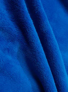 Dettaglio della texture del tessuto in pile corallo blu, primo piano di materiale caldo morbido.