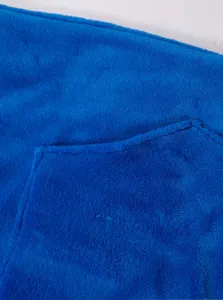Dettaglio in tessuto di pile corallo blu, morbida consistenza calda della tasca.