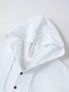 Gros plan détaillé d'une chemise à capuche en lin et coton blanc avec boutons et cordons.