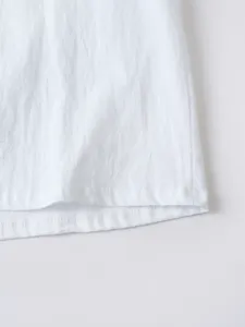 Gros plan détaillé du bas de la chemise blanche en coton et lin avec belles coutures.