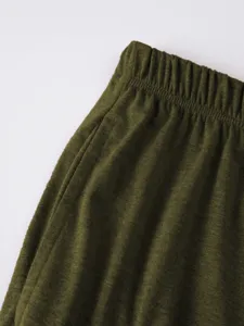 Close-up detail of mens green casual shorts elastic waistband pocket texture fabric surface.