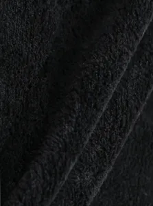 Primo piano dettagliato del tessuto in pile corallo nero con consistenza morbida.