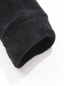 Primo piano del dettaglio del polsino in pile nero con tessuto invernale morbido e caldo.