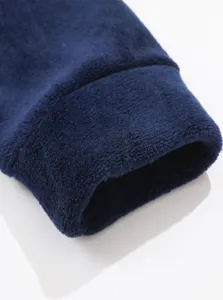 Dettaglio ravvicinato del polsino della felpa in pile blu scuro, tessuto morbido.