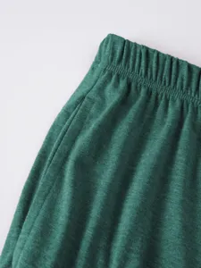Detailed view of men's casual shorts elastic waistband textured green fabric summer wear