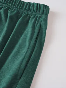 Men's casual shorts fabric detail, dark green textured elastic waist with side pockets.
