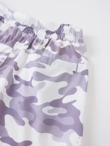 Gros plan détaillé de shorts de sport camouflage violet pour homme avec cordon élastique.