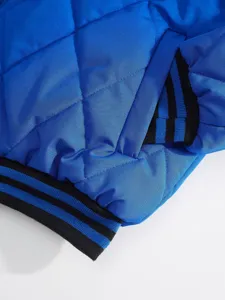 Detailed view of men's blue quilted jacket with black striped ribbed cuffs and hem.