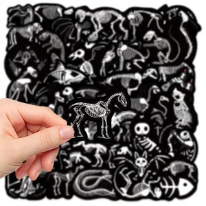 Vista dettagliata di un adesivo impermeabile con scheletro animale nero tra le mani.