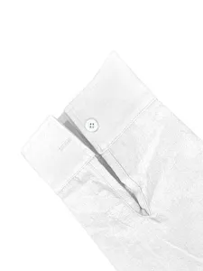 Primo piano del polsino della camicia da uomo bianca, con bottone e classico spacchetto.