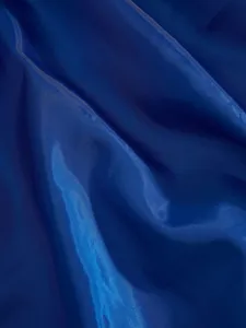 Close-up of deep blue fabric texture, smooth and glossy textile detail for apparel design.