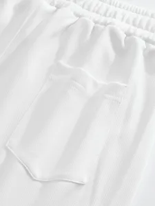 Gros plan sur les détails de la ceinture et de la poche arrière du short pour hommes blanc.