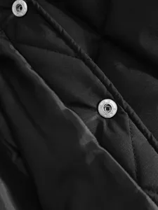 Close-up detail view showing the texture of the black quilted jacket fabric and metal snap buttons.