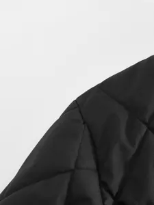 Black quilted jacket shoulder detail close-up, showing fine stitching and texture.