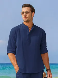 Close-up detail of mens summer solid blue linen mandarin collar casual shirt beach outdoor scene