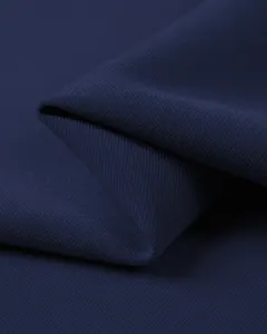 Close up of dark blue polo shirt fabric detail, showing soft texture and fine weave.