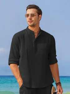 Close-up detail of men casual mandarin collar linen shirt worn by model on beach scene.