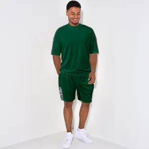 Détail de l'ensemble t-shirt et short gaufré vert foncé avec bande imprimée sur le côté.