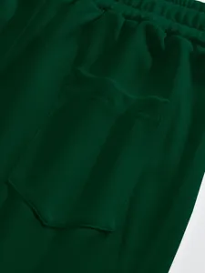 Gros plan de tissu gaufré vert foncé, taille élastique et design de poche pratique.