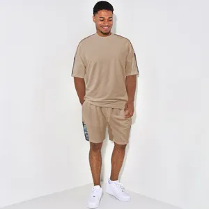 Ensemble t-shirt et short casual pour homme beige avec bandes imprimées sur les côtés.
