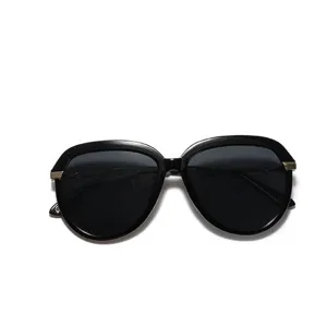 Chic oversized black aviator sunglasses with gold metal accents in a minimalist style
