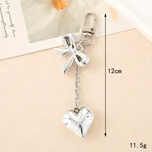 Minimalist shiny silver metal keychain with bow and heart charms for bags or phones
