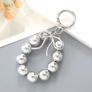 Silver metallic bead bag charm with bow accent and circular spring ring