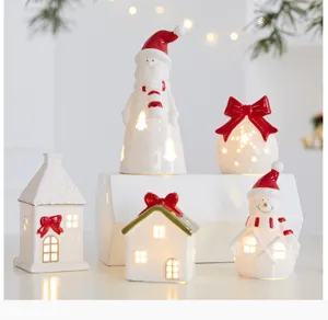 Close-up macro view of ceramic Christmas light-up house and Santa ornaments