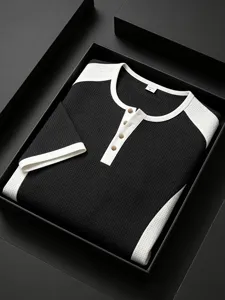 Detail view of the black and white color block waffle knit men's henley short sleeve shirt.
