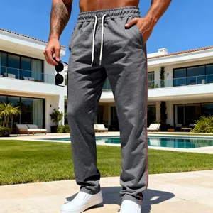 Detail view of men's casual grey sweatpants with side stripe and drawstring waist outdoors.