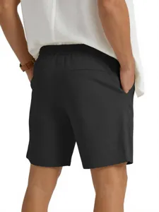 Vista dettagliata di pantaloncini casual neri da uomo con coulisse elastica e camicia bianca.