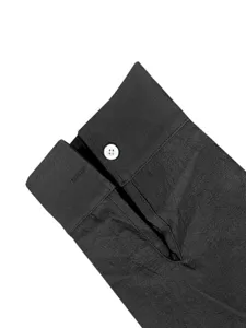 Dettaglio polsino camicia uomo manica lunga, tessuto nero traspirante, un bottone.