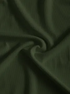 Gros plan détaillé de la texture en tricot gaufré vert foncé avec une surface douce.