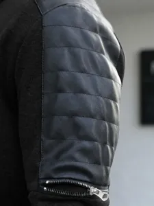 Detail view of men's casual jacket sleeve with faux leather quilted texture and metal zipper.