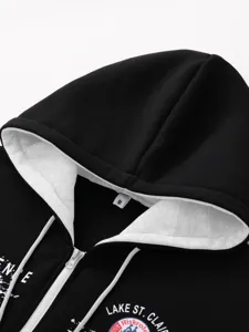 Men black zip-up hoodie detail view, grey hood lining white drawstring and graphic print.