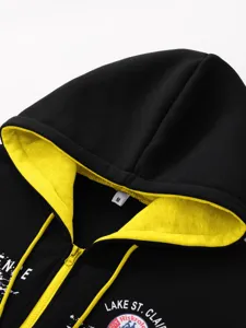 Men's black and yellow zip-up hoodie detail view, featuring hood, drawstrings, and chest print.