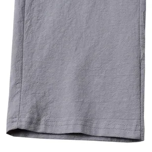 Gros plan détaillé de la texture du tissu de pantalon en lin gris et manchette fine