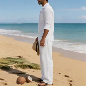 Vista detallada de la camisa de lino blanca de manga larga y los pantalones en la playa.
