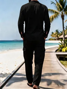 Details of black linen long sleeve men shirt on beach scene, casual summer lifestyle product view.