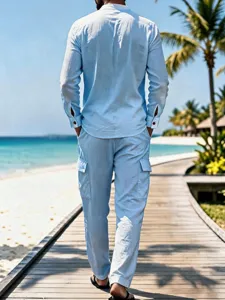 Detailed view of men's casual light blue linen long sleeve shirt in beach outdoor scene.
