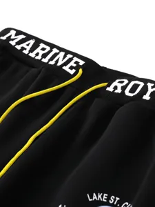 Detailed view of black sweatpants elastic waistband with contrasting yellow drawstrings.