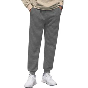 Close-up detail of casual grey waffle knit jogger pants for men, featuring comfortable fit.