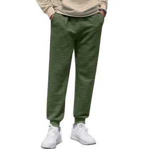 Detail view of men green waffle knit casual sweatpants comfortable regular fit trousers.