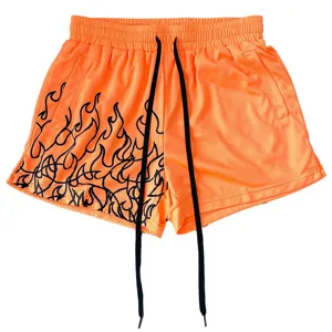 Orangene Mesh-Sportshorts mit schwarzem Flammen-Print und langen Kordelzügen für das Training.