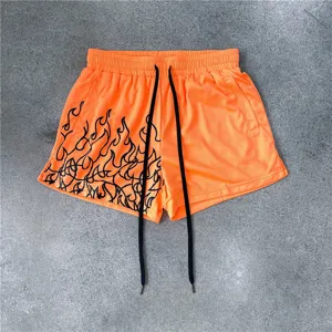 Detailansicht der leuchtend orangefarbenen Herren Mesh Sporthose mit Flammenprint.