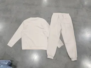 Détail ensemble de survêtement beige, sweatshirt minimaliste et pantalon confortable.