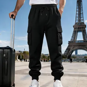 Outdoor detail shot of mens black fleece cargo pants with drawstring waist and deep pockets.