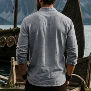 Close-up detail of men's casual long sleeve linen shirt with stand collar in light blue.